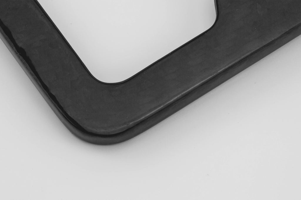 Close-up view of the Ultimate Carbon Fiber License Plate Frame, highlighting its carbon fiber texture